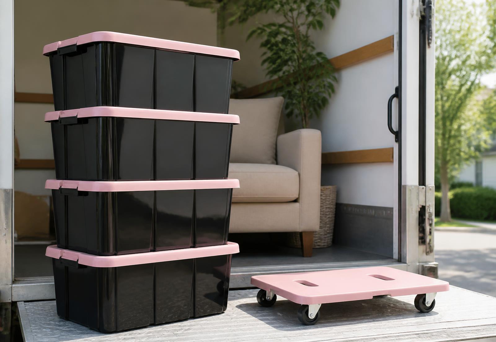 Stack of black Tote & Go Co. moving totes with pink lids and a pink dolly at the back of a moving truck